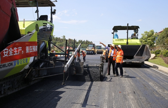 攤鋪機(jī)、壓路機(jī)等設(shè)備緊張有序運(yùn)行，高達(dá)170℃的瀝青混合料炙烤著公路人
